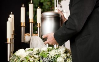 Religion, death and dolor  - mortician on funeral with urn